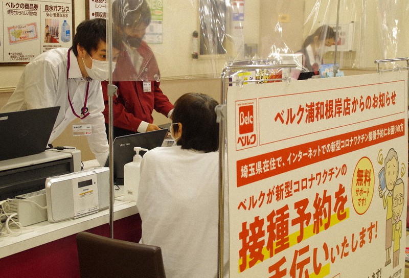スーパー「ベルク」でワクチン接種予約の手伝いを受ける高齢者(中央)=さいたま市南区で2021年6月9日午後4時15分、山越峰一郎撮影