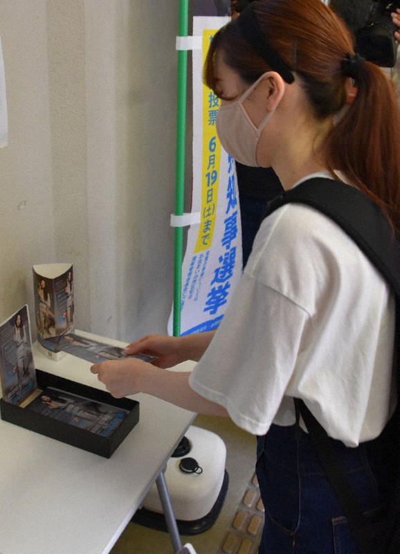 知事選啓発用品のマスクケースを手に取る学生=静岡市の県立大草薙キャンパスで2021年6月11日、山田英之撮影