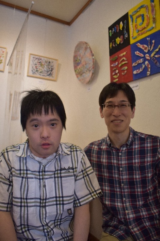 作品が並ぶ会場で彰悟さん(左)と父伸一さん