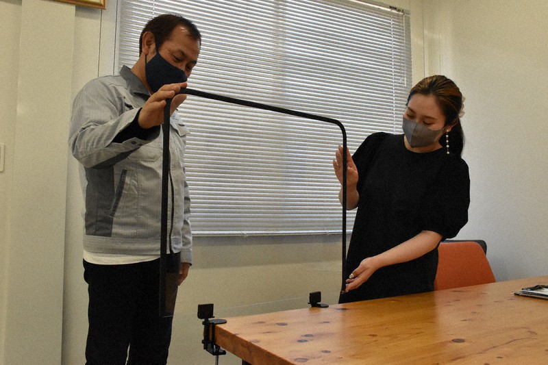寺島充博さん(左)と次女希さんが設計した「メカ屋が作ったアクリルパーテーション」=大津市松本2のティーズモデリング大津事業所で2021年5月31日午後2時41分、菅健吾撮影