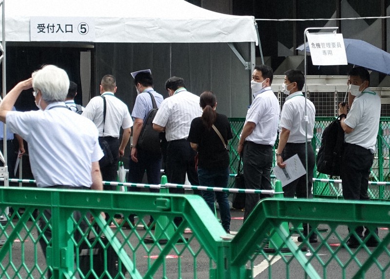 小雨がぱらつく中、大規模接種センターの「危機管理要員専用」の受付に並ぶ人たち=東京都千代田区で2021年6月14日午後4時30分、井口慎太郎撮影