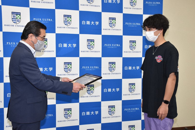 大貫良之生活安全部長から感謝状を渡される藤本壮さん=栃木県小山市の白鷗大で2021年6月15日午後1時半、鴨田玲奈撮影