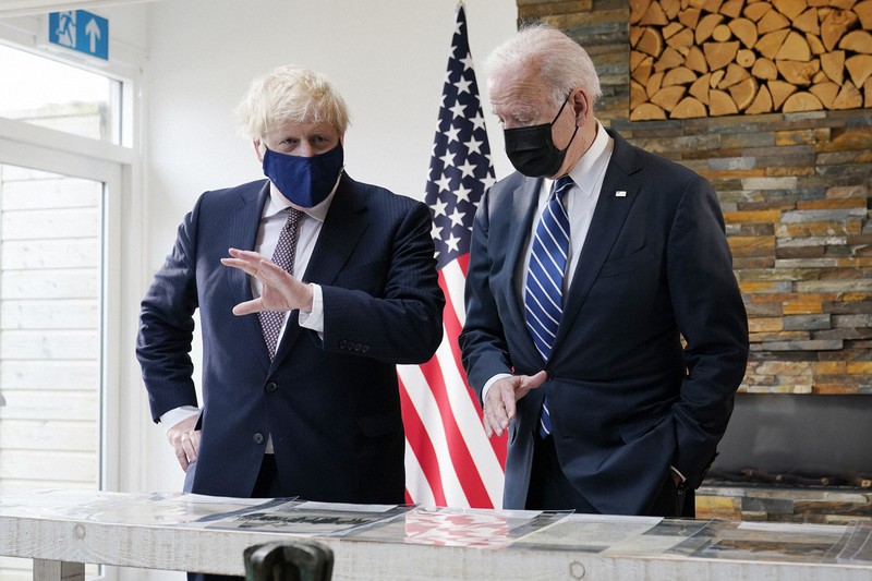 主要7カ国首脳会議(G7サミット)に先立ち行われた米英首脳会談で、大西洋憲章の写しを眺めるジョンソン英首相(左)とバイデン米大統領=英南西部コーンウォールで2021年6月10日、AP