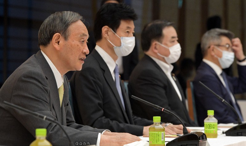 経済財政諮問会議・成長戦略会議の合同会議で発言する菅義偉首相(左)。左から2人目は西村康稔経済再生担当相=首相官邸で2021年6月18日午後5時52分、竹内幹撮影