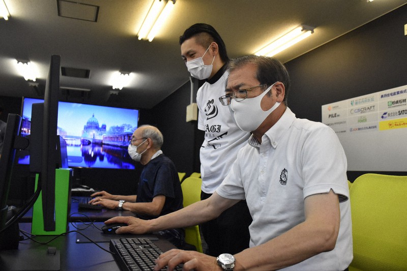 説明会でゲームに早速挑戦する参加者ら=秋田市で2021年6月18日午後2時48分、高野裕士撮影