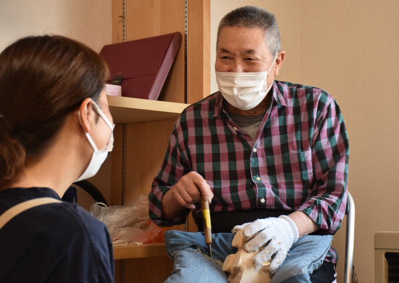 木彫り熊の町民講座で、受講生にほほ笑みながら指導する講師の千代昇さん=北海道八雲町で2021年6月5日午前11時6分、真貝恒平撮影