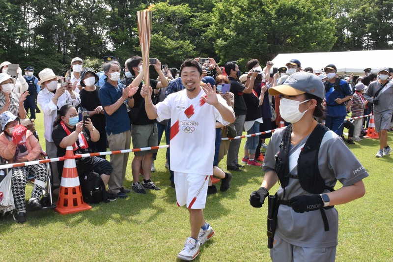 聖火ランナーとして故郷の岩手県北上市を走るプロボクシング元3階級王者の八重樫東さん=同県北上市で2021年6月18日午後1時38分、山田豊撮影