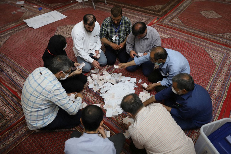 イラン大統領選の投票終了後、票の集計作業にあたる選管職員=テヘランで2021年6月19日、ロイター