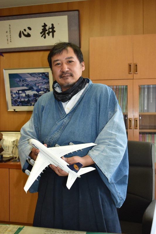 飛行機模型を手に、校長室で大空高の魅力を語る大辻さん=北海道大空町で2021年6月2日、本多竹志撮影