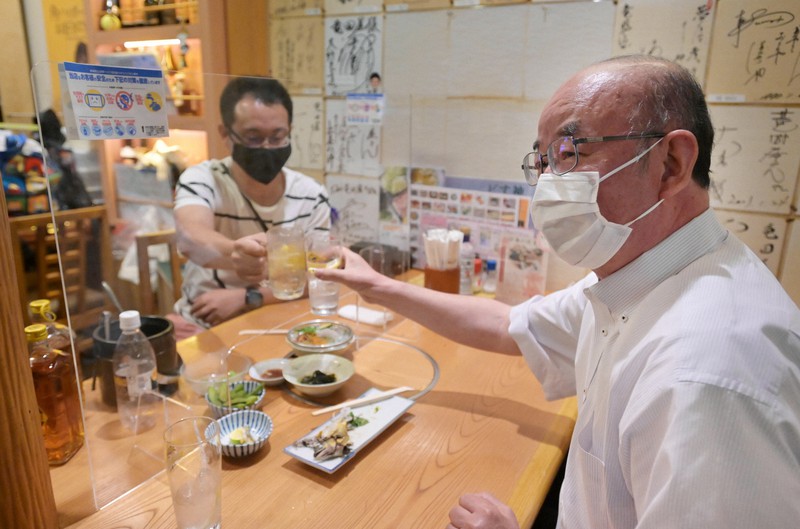 緊急事態宣言が解除され、居酒屋でアクリル板越しに乾杯し飲酒を楽しむ人たち=大阪市中央区の「竜田屋」で2021年6月21日午後5時19分、加古信志撮影