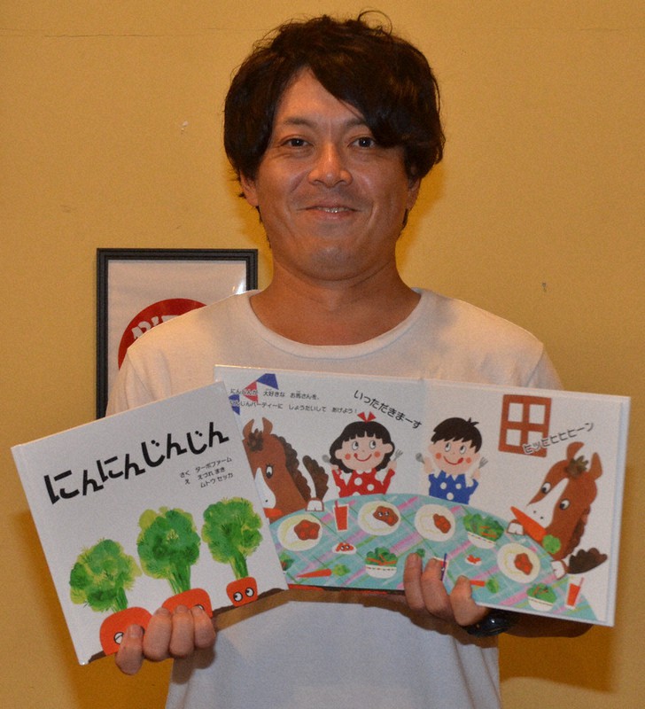 絵本を手にする高橋忠浩さん＝茨城県古河市下辺見で2021年6月4日午後3時0分、安味伸一撮影