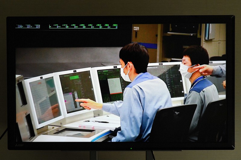 中継モニターに映し出された、関西電力美浜原発3号機の中央制御室で起動の操作をする運転員の様子=福井県美浜町の関電原子力事業本部で2021年6月23日午前10時(代表撮影)