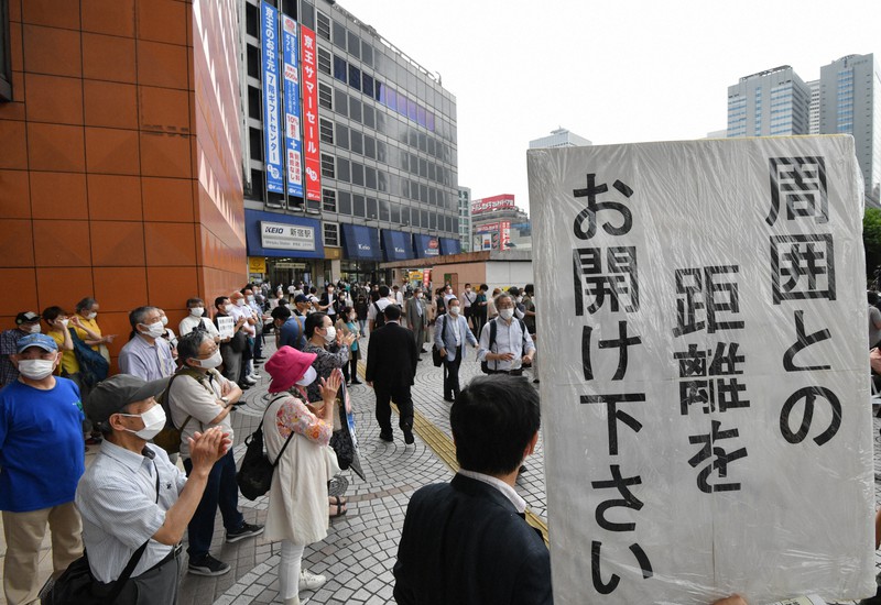 東京都議選が告示され、街頭で演説を聞く人たち=東京都新宿区で2021年6月25日午前10時4分、宮間俊樹撮影