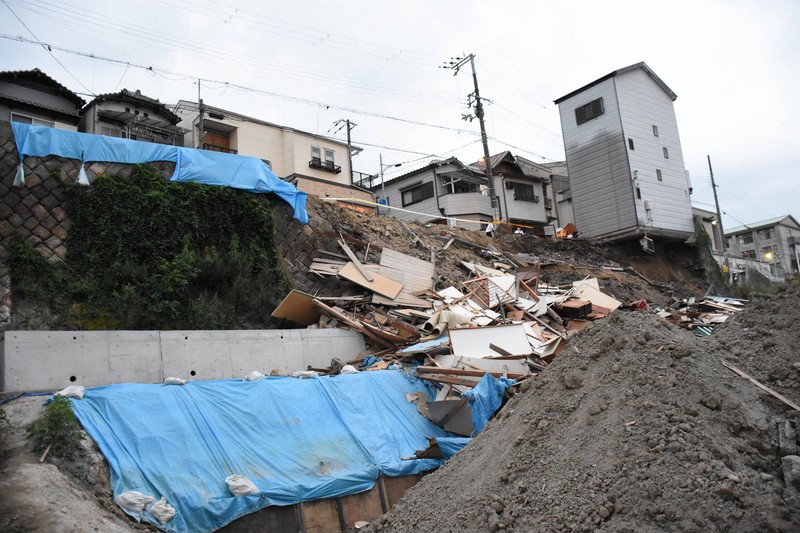 住宅2棟が崩落した現場。南隣の住宅も土地の一部が崩れ、倒壊の恐れが出ている=大阪市西成区で2021年6月25日午後7時21分、郡悠介撮影