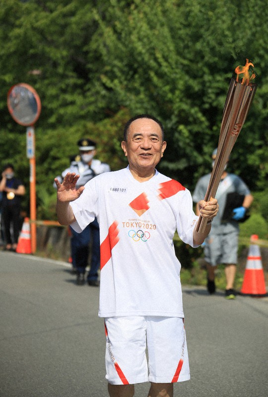 聖火を手に走る三遊亭小遊三さん=山梨県笛吹市で2021年6月27日(代表撮影)