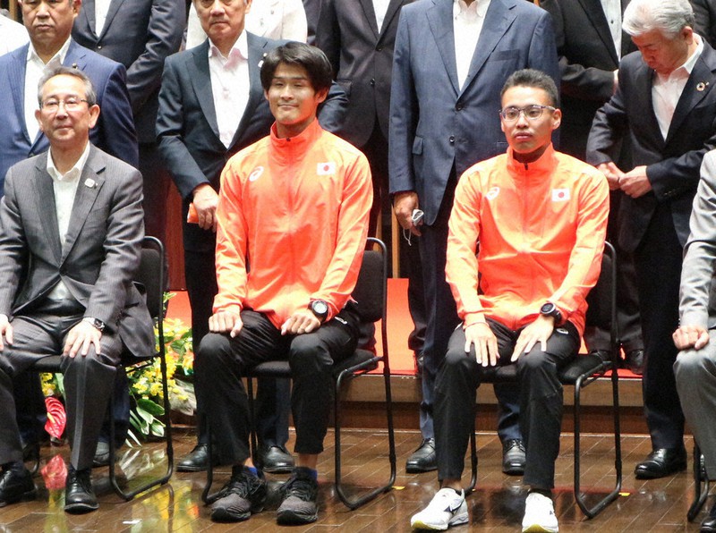 壮行会参加者と記念写真に収まる山西利和選手(右)と丸尾知司選手(中央)=愛知県東海市芸術劇場で2021年6月25日、黒尾透撮影