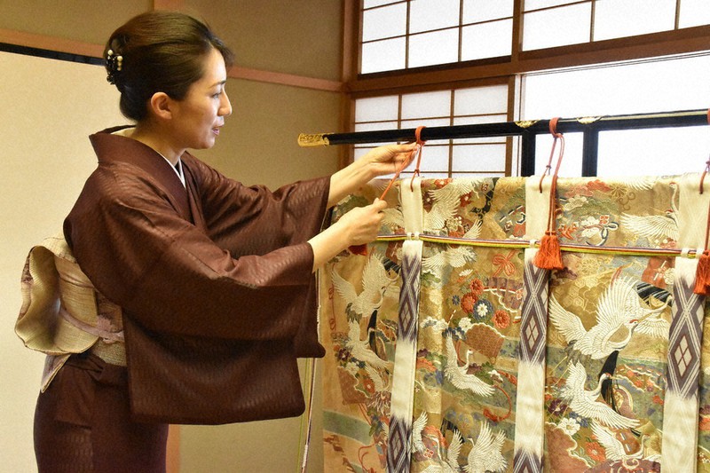 対局室に飾る几帳を整える女将の寺田まりさん=三重県鳥羽市鳥羽1の「戸田家」で021年6月25日、寺原多惠子撮影