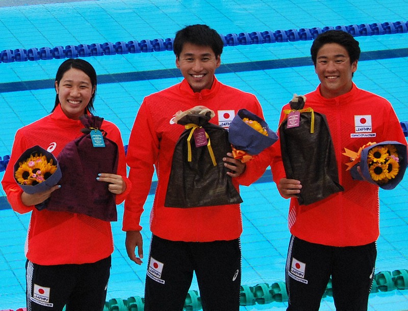 花束を手に笑顔を見せる(左から)難波実夢選手、砂間敬太選手、佐藤翔馬選手=奈良県大和郡山市で、田中なつみ撮影