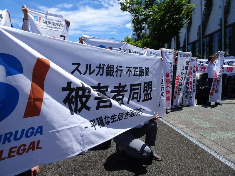 スルガ銀行の株主総会終了後、会場前で横断幕を掲げる購入者たち=静岡県沼津市で2021年6月29日、今沢真撮影
