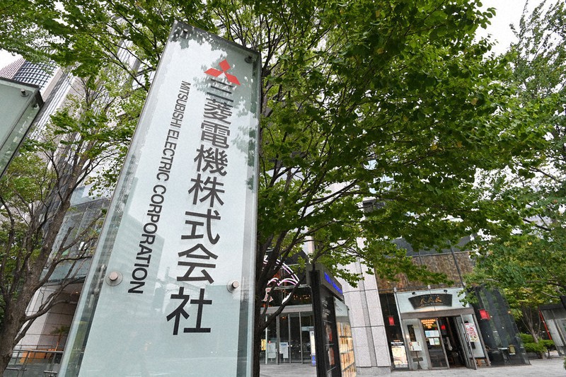 三菱電機本社が入るビルの前にある看板=東京都千代田区で6月30日、大西岳彦撮影