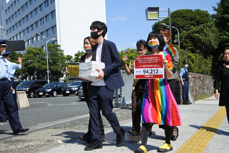 自民党議員による差別発言の撤回と謝罪を求めて集まった9万筆を超える署名を提出するため、自民党本部に向かう人たち。署名を抱えるのは松岡さん=東京都千代田区の自民党本部前で5月31日、藤沢美由紀撮影