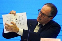 In this Feb. 9, 2021, file photo, Peter Ben Embarek of the World Health Organization team holds up a chart showing pathways of transmission of the virus during a joint news conference at the end of the WHO mission in Wuhan in central China's Hubei province. (AP Photo/Ng Han Guan)