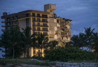 In this June 30, 2021, file photo, light shines on the Champlain Towers South as search and rescue teams continue looking for survivors of the partially collapsed residential building in Surfside, Fla. (Pedro Portal/Miami Herald via AP)