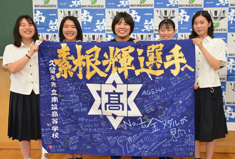 応援メッセージが書かれた校旗を手にする素根選手(中央)とエールを送った在校生