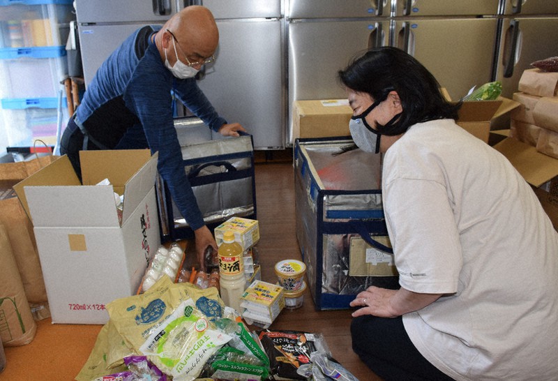 おおさかパルコープの浅田伸一さん(左)が配達した食品を整理する「にしなり☆こども食堂」の川辺康子さん=大阪市西成区で2021年6月14日午後4時20分、柳楽未来撮影