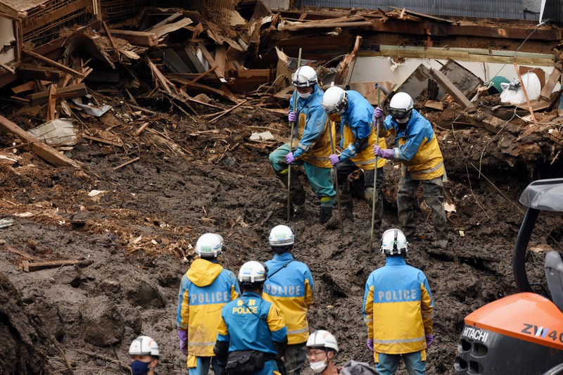 土石流に襲われた住宅街で行方不明者を捜す警察官ら=静岡県熱海市伊豆山で2021年7月7日午後1時58分、丸山博撮影