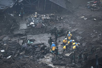 土石流に覆われた住宅地で捜索を続ける警察官や自衛隊員ら＝静岡県熱海市伊豆山で2021年7月9日7時38分、手塚耕一郎撮影