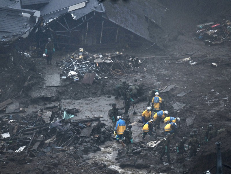 土石流に覆われた住宅地で捜索を続ける警察官や自衛隊員ら=静岡県熱海市伊豆山で2021年7月9日7時38分、手塚耕一郎撮影