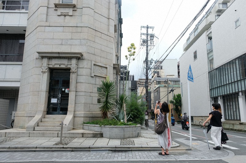 三条通に面した花壇に咲いたリュウゼツランの花。通りかかった人が写真を撮るなどしていた=京都市中京区で2021年7月9日午後4時37分、千金良航太郎撮影
