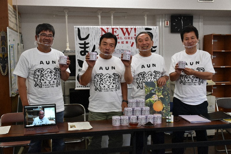 商品を手に笑顔を見せる馬路村農協の東谷組合長(右から2番目)ら=県庁で2021年7月7日午前11時30分、北村栞撮影