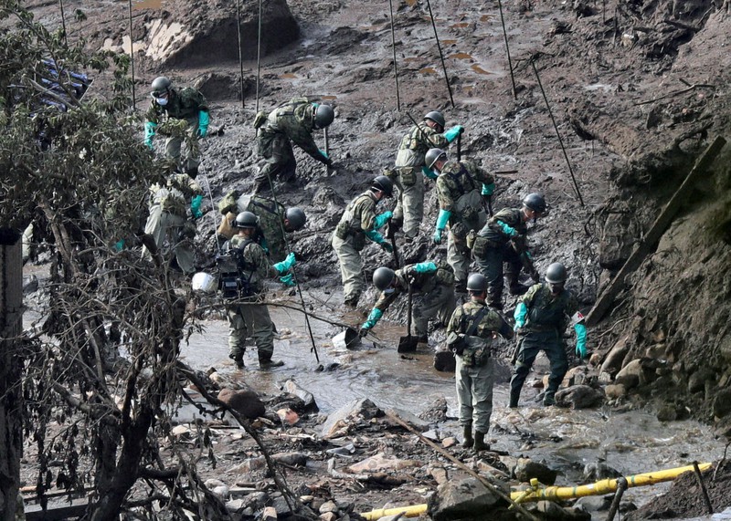 大量の泥が積もった土石流災害現場で捜索を続ける自衛隊員ら=静岡県熱海市伊豆山で2021年7月10日午前7時8分、吉田航太撮影