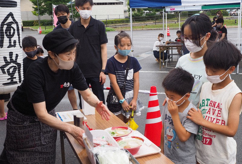 ラーメンを受け取る子供たち