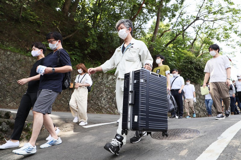 一時帰宅のため、土石流が起きた現場近くの自宅などに向かう住民ら=静岡県熱海市で2021年7月12日午前9時13分、吉田航太撮影