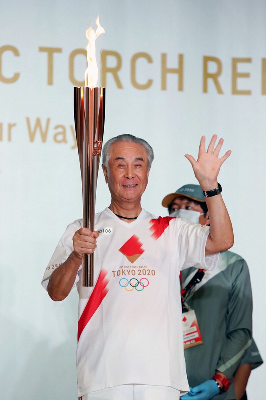 聖火を手にする鷹城勲さん=東京都立川市で2021年7月12日(代表撮影)
