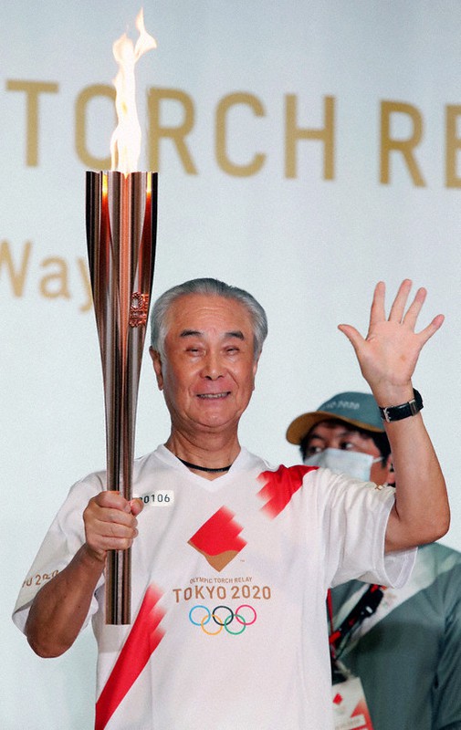 聖火を手にする鷹城勲さん=東京都立川市で12日(代表撮影)
