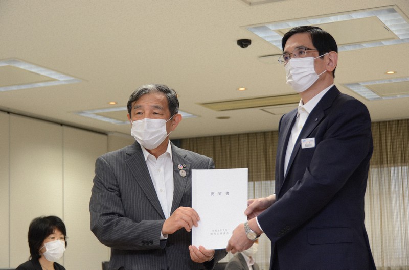 新型コロナウイルスによる減便計画について、JR西日本の長谷川一明社長(右)に要望書を手渡す関西広域連合の仁坂吉伸連合長(和歌山県知事)=大阪市北区のJR西日本本社で2021年7月13日午後3時59分、鶴見泰寿撮影