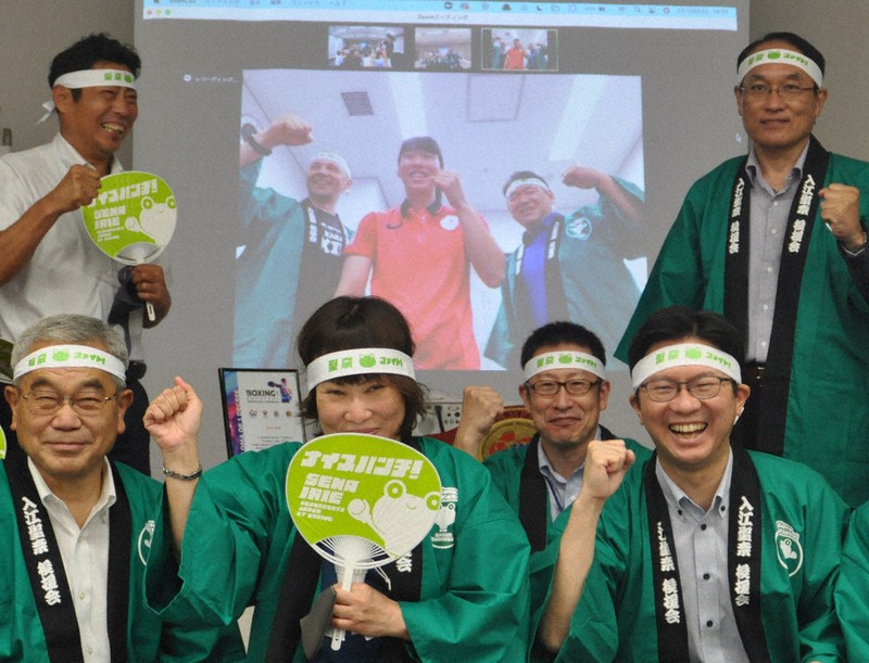 入江聖奈選手(画面中央)を囲んで気勢を上げる後援会関係者ら=鳥取県米子市末広町で、柴崎達矢撮影