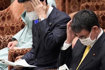 衆院内閣委員会で共産党の塩川鉄也氏の質問を聞く西村康稔経済再生担当相（左）。右は河野太郎行政改革担当相＝国会内で2021年7月14日午前11時18分、竹内幹撮影