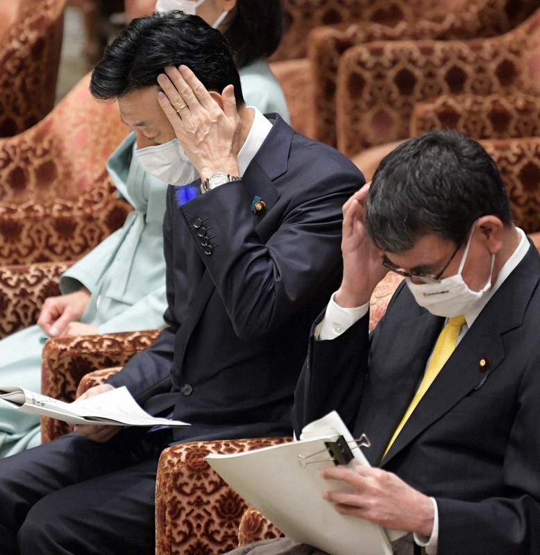 衆院内閣委員会で共産党の塩川鉄也氏の質問を聞く西村康稔経済再生担当相(左)。右は河野太郎行政改革担当相=国会内で2021年7月14日午前11時18分、竹内幹撮影