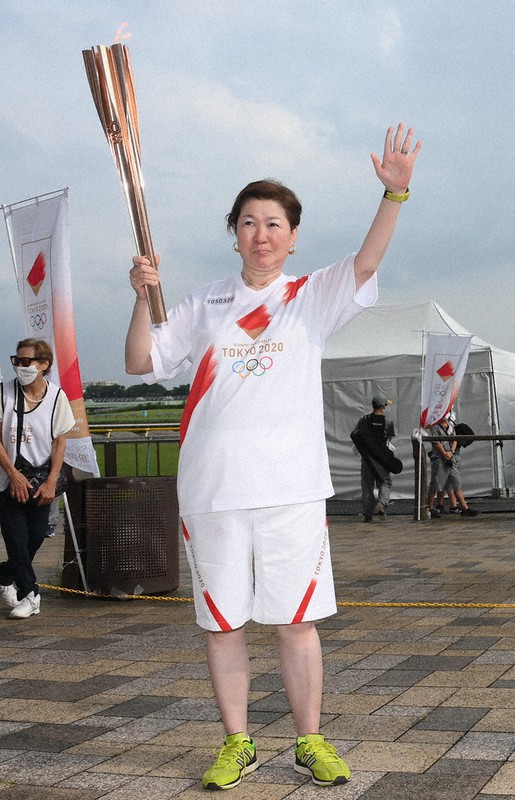 聖火を手にする小畑由利さん=東京都府中市の東京競馬場で2021年7月14日(代表撮影)