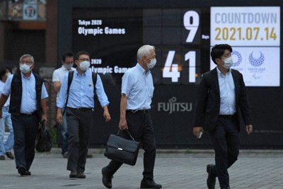 東京五輪開幕まであと9日を示すカウントダウンボードの前をマスク姿で行き交う人たち＝東京都港区の新橋駅前で2021年7月14日、手塚耕一郎撮影