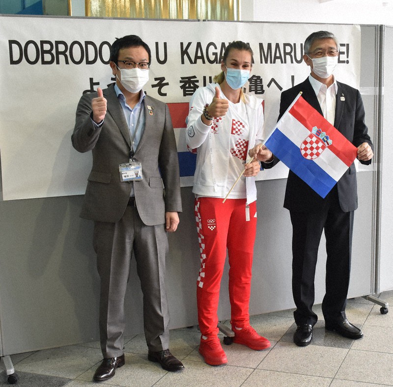 高松空港で出迎えた西原義一副知事(右)、丸亀市の横田拓也副市長(左)と記念撮影する東京五輪クロアチア代表のサラ・コラク選手=香川県高松市で、川原聖史撮影