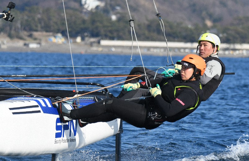 東京オリンピックに向け練習するセーリング・ナクラ17級日本代表の飯束潮吹(奥)と畑山絵里。風が強まれば、体を目いっぱい乗り出してバランスを取る=神奈川・葉山沖で2020年3月6日午後3時1分、細谷拓海撮影
