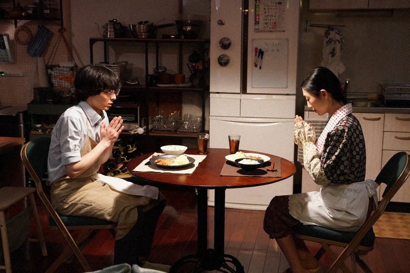 食卓をはさむ和田理生(高杉真宙)とあきたなでしこ(壇蜜)=Ⓒ「妄想ごはん」製作委員会