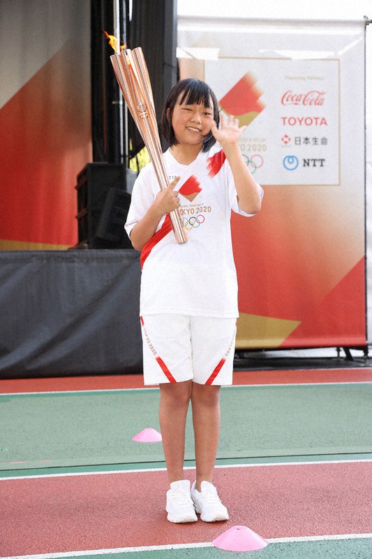聖火を手にする馬場乙嘉さん=東京都武蔵野市で2021年7月16日午後5時(代表撮影)
