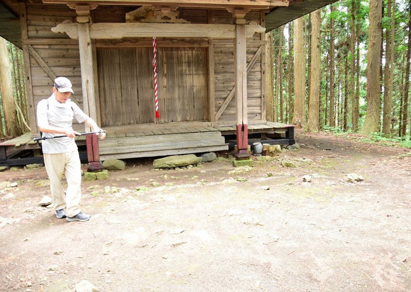 黒又山頂上で神様が降り立ったとされる磐座を見て回る阿部安男さん=2021年7月8日、秋田県鹿角市十和田大湯で田村彦志撮影